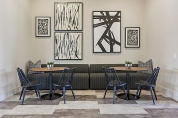 A black and white abstract painting hangs above a black couch.